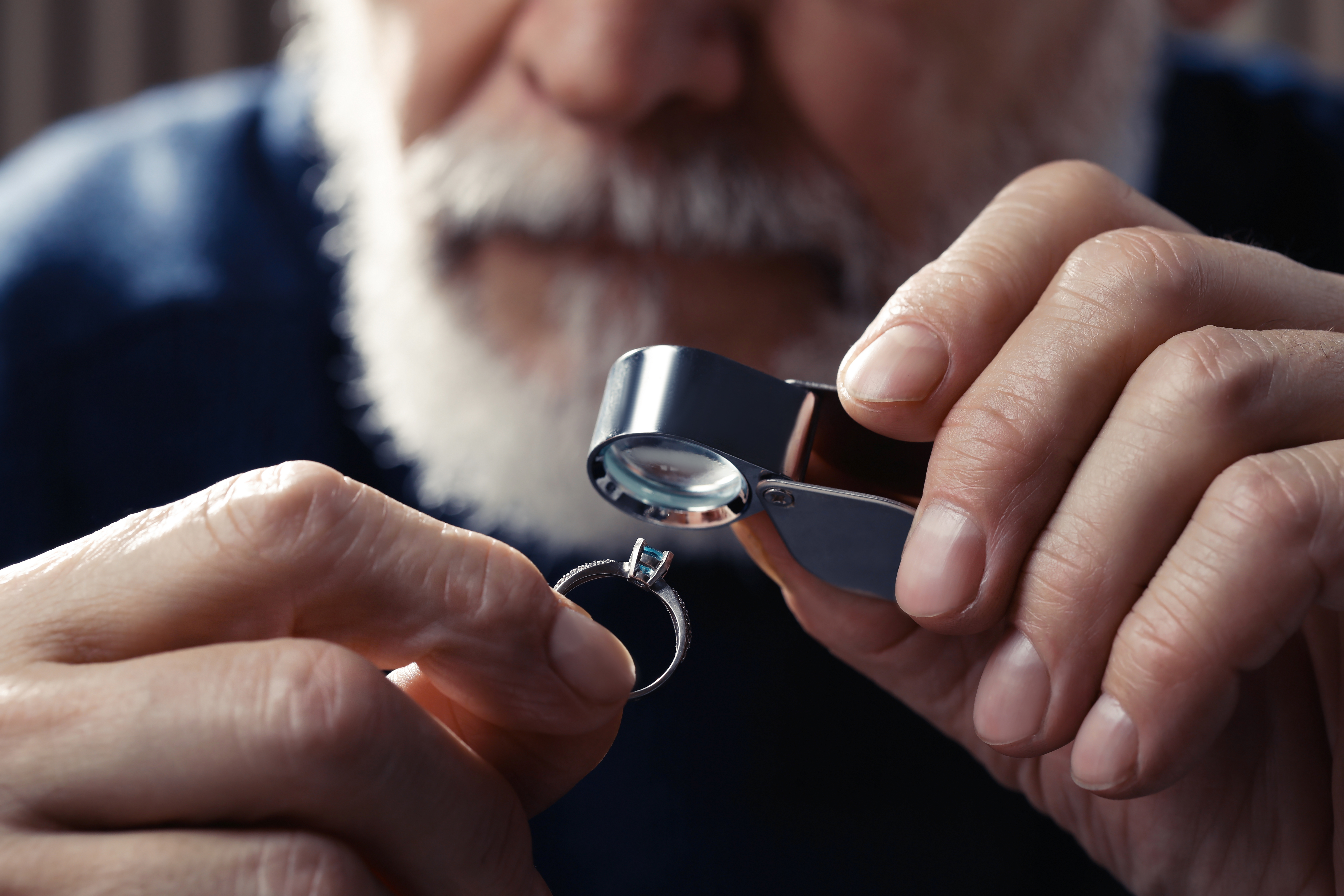 Close-up of a magnifying glass inspecting a hallmark